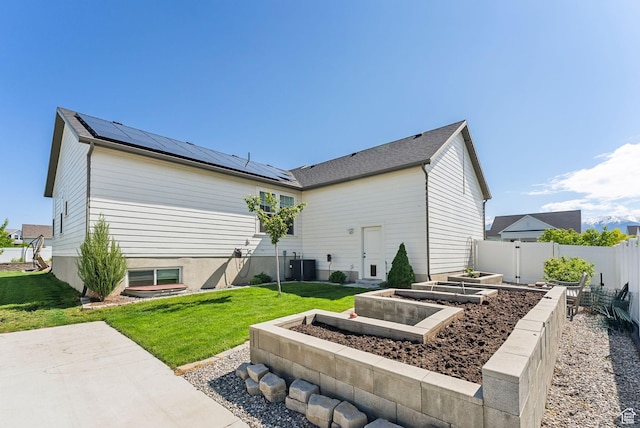 222 S Summer Breeze Ln, Layton, UT 84041 - rear view of house with a vegetable garden, solar panels, and central AC unit
