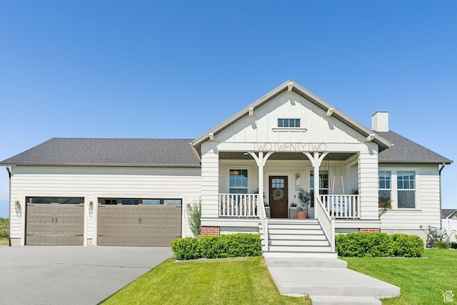 222 S Summer Breeze Ln, Layton, UT 84041 - view of front of house featuring covered porch, a garage, board and batten siding, a front lawn, and concrete driveway