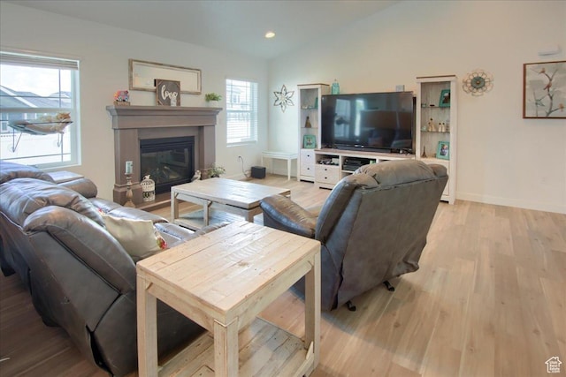 958 W Regatta Ln, Stansbury Park, UT 84074 - living area with light wood-style flooring, vaulted ceiling, a glass covered fireplace, and baseboards