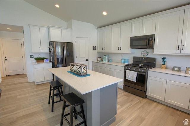 958 W Regatta Ln, Stansbury Park, UT 84074 - kitchen featuring stainless steel appliances, vaulted ceiling, a kitchen breakfast bar, light wood finished floors, and recessed lighting