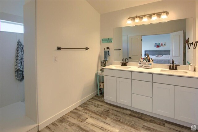 958 W Regatta Ln, Stansbury Park, UT 84074 - bathroom with double vanity, wood finished floors, ensuite bathroom, and baseboards
