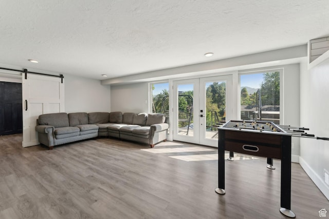 3407 S 325 W, Bountiful, UT 84010 - living room with a barn door, french doors, a textured ceiling, wood finished floors, and recessed lighting