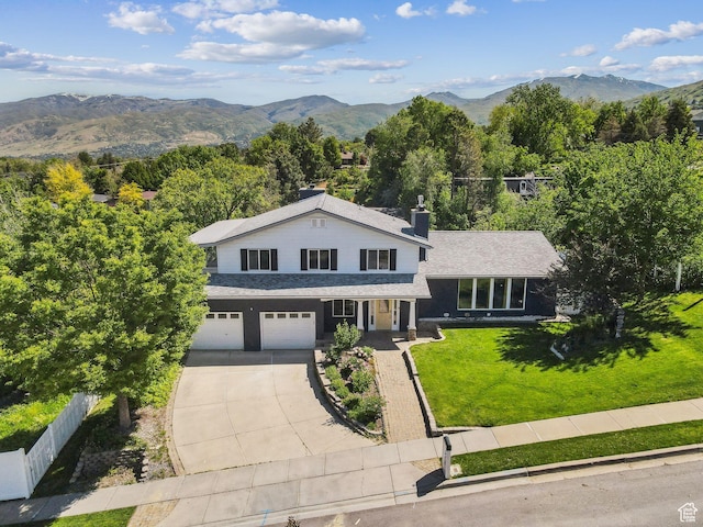3407 S 325 W, Bountiful, UT 84010 - view of front of home with driveway, an attached garage, a mountain view, and a chimney