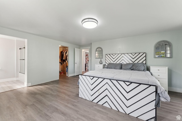 3407 S 325 W, Bountiful, UT 84010 - bedroom featuring wood finished floors, a walk in closet, a closet, baseboards, and connected bathroom