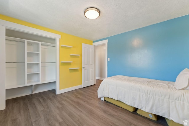 3407 S 325 W, Bountiful, UT 84010 - bedroom featuring wood finished floors, baseboards, a textured ceiling, and a closet