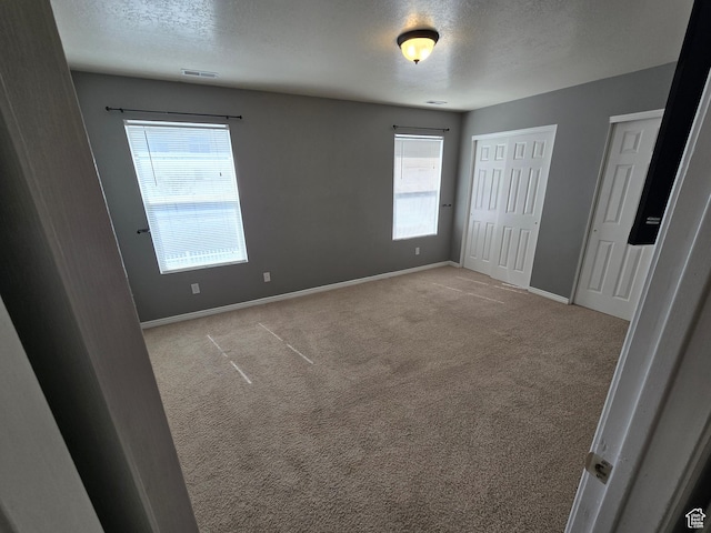 4043 S Lake Vista Dr, Saratoga Springs, UT 84045 - unfurnished bedroom featuring multiple closets, a textured ceiling, baseboards, and carpet