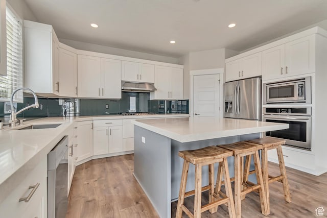 3727 N 900 W, Lehi, UT 84043 - kitchen with stainless steel appliances, a sink, a kitchen bar, light wood-style flooring, and a kitchen island