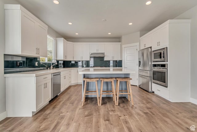 3727 N 900 W, Lehi, UT 84043 - kitchen with appliances with stainless steel finishes, a breakfast bar, white cabinetry, a kitchen island, and recessed lighting