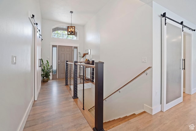 890 E 20 N, Smithfield, UT 84335 - foyer entrance featuring a barn door, light wood-type flooring, baseboards, a chandelier, and a high ceiling