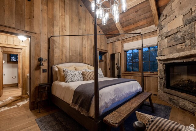 11042 E Wild Elk Mdw, Heber City, UT 84032 - bedroom with wood walls, high vaulted ceiling, light wood-style flooring, a fireplace, and a chandelier