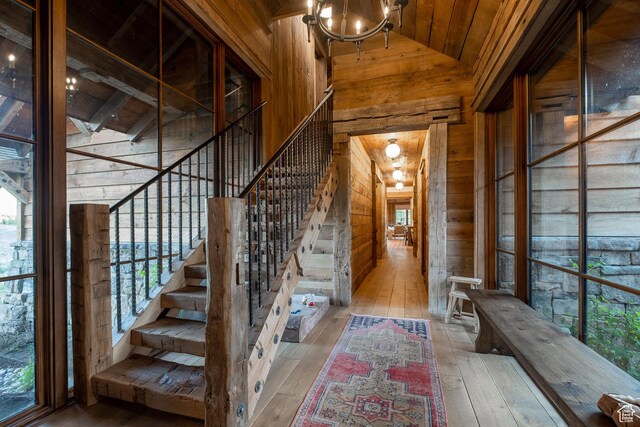 11042 E Wild Elk Mdw, Heber City, UT 84032 - stairway featuring wooden walls, wooden ceiling, wood-type flooring, a chandelier, and high vaulted ceiling