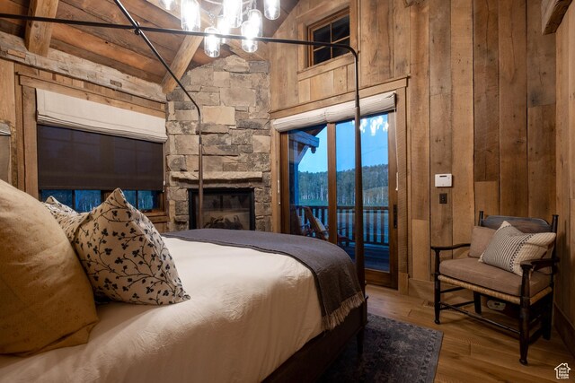 11042 E Wild Elk Mdw, Heber City, UT 84032 - bedroom featuring wood walls, access to exterior, wood-type flooring, a fireplace, and a chandelier