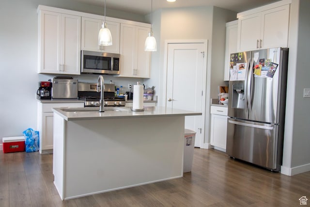 3717 S 3250 W Unit E33, West Haven, UT 84401 - kitchen featuring appliances with stainless steel finishes, dark wood-style floors, white cabinets, pendant lighting, and an island with sink