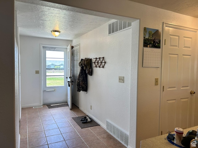 545 E Molen Rd, Ferron, UT 84523 - doorway to outside featuring tile patterned flooring, a textured ceiling, a textured wall, and baseboards
