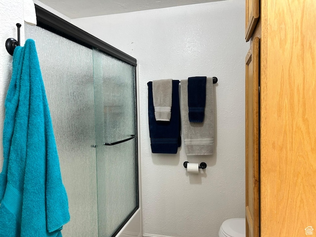 545 E Molen Rd, Ferron, UT 84523 - bathroom with toilet, bath / shower combo with glass door, a textured wall, and baseboards