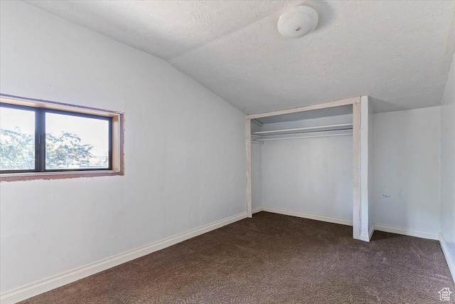 660 S Coleman St, Tooele, UT 84074 - unfurnished bedroom with vaulted ceiling, dark colored carpet, a closet, a textured ceiling, and baseboards