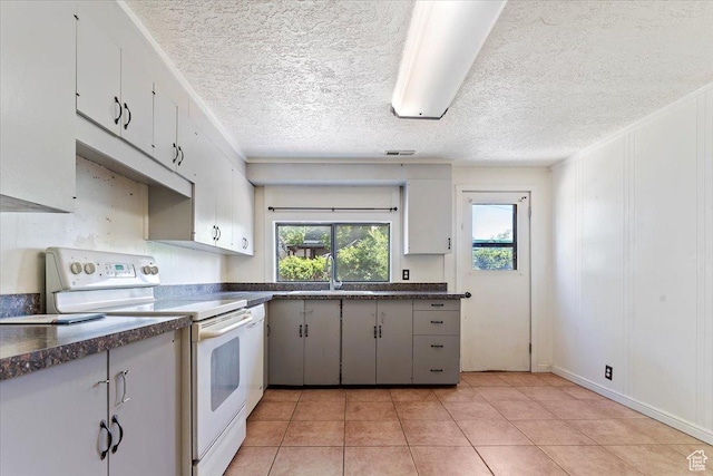 660 S Coleman St, Tooele, UT 84074 - kitchen with electric stove, dark countertops, a sink, light tile patterned floors, and a textured ceiling
