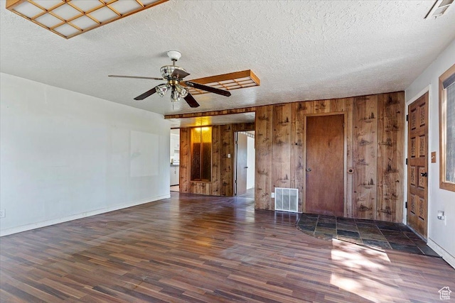660 S Coleman St, Tooele, UT 84074 - unfurnished living room featuring wood finished floors, a textured ceiling, wooden walls, a ceiling fan, and baseboards