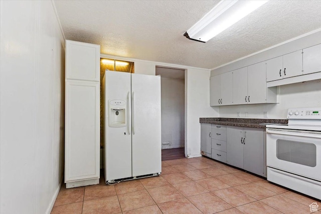 660 S Coleman St, Tooele, UT 84074 - kitchen with white appliances, a textured ceiling, dark countertops, white cabinetry, and baseboards