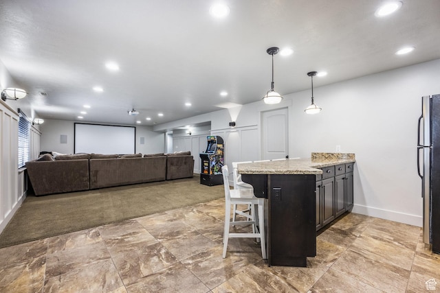 2949 W Hayden Ridge Way, Riverton, UT 84065 - kitchen featuring a peninsula, a kitchen bar, light stone counters, recessed lighting, and baseboards