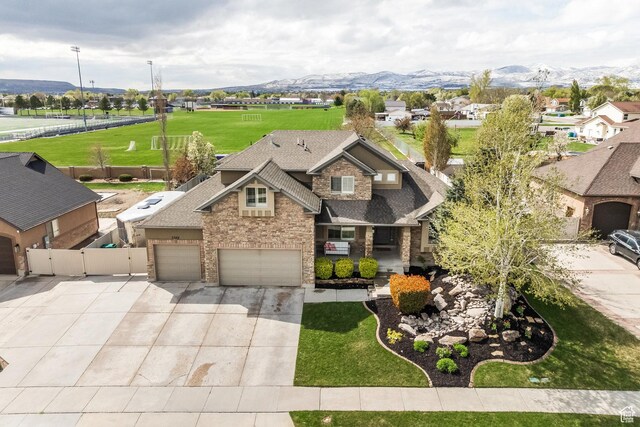 2949 W Hayden Ridge Way, Riverton, UT 84065 - view of front of home featuring concrete driveway, a shingled roof, a mountain view, and brick siding