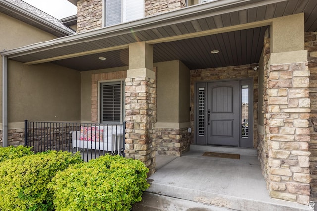 2949 W Hayden Ridge Way, Riverton, UT 84065 - doorway to property with stucco siding, stone siding, and covered porch