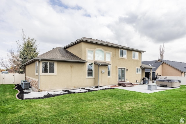 2949 W Hayden Ridge Way, Riverton, UT 84065 - back of property featuring a hot tub, a patio area, stucco siding, and central AC