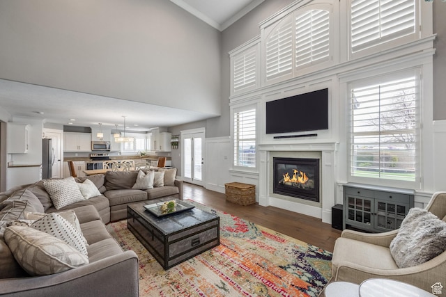 2949 W Hayden Ridge Way, Riverton, UT 84065 - living room featuring a glass covered fireplace, wood finished floors, a high ceiling, and ornamental molding