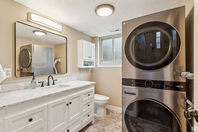 518 E 3955 S, Millcreek, UT 84107 - bathroom featuring stacked washing machine and dryer, vanity, toilet, and baseboards