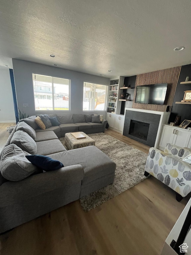 2323 W Thomas Ct, Syracuse, UT 84075 - living area with wood finished floors, a textured ceiling, and a fireplace