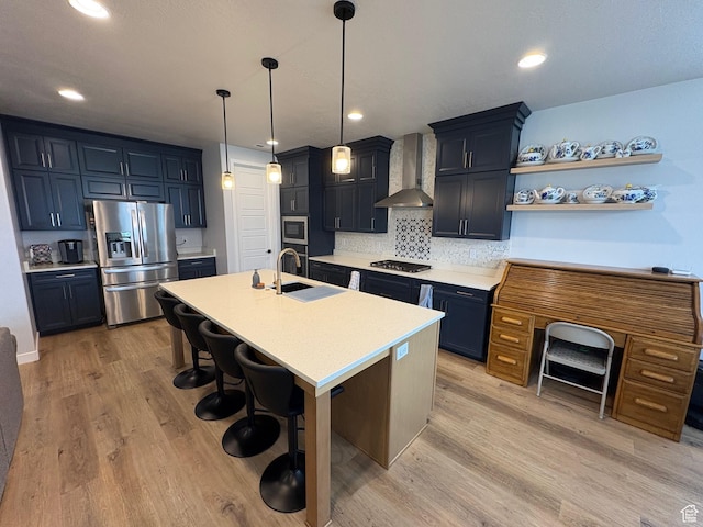 2323 W Thomas Ct, Syracuse, UT 84075 - kitchen with stainless steel appliances, wall chimney range hood, a sink, light countertops, and decorative backsplash