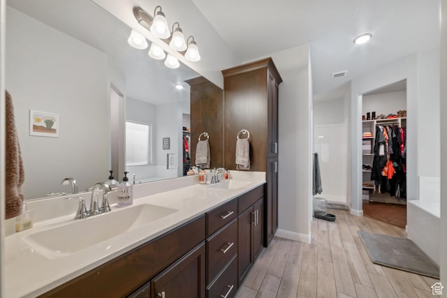 478 S Albano Way, St George, UT 84770 - bathroom featuring double vanity, a walk in closet, wood finished floors, and baseboards