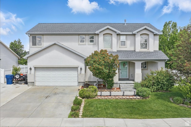 122 W Stern Ct Unit 25, Stansbury Park, UT 84074 - traditional-style home featuring stucco siding, an attached garage, concrete driveway, and a front lawn