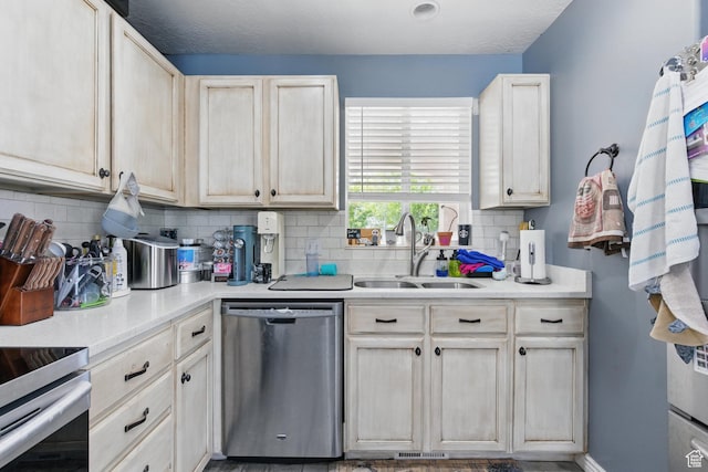 122 W Stern Ct Unit 25, Stansbury Park, UT 84074 - kitchen with dishwasher, a sink, tasteful backsplash, and light countertops