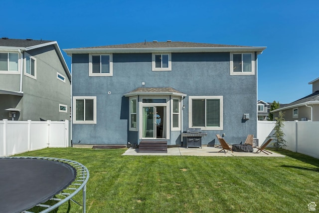 10966 S Coastal Dune Dr, South Jordan, UT 84009 - back of house featuring a trampoline, stucco siding, a patio, and entry steps