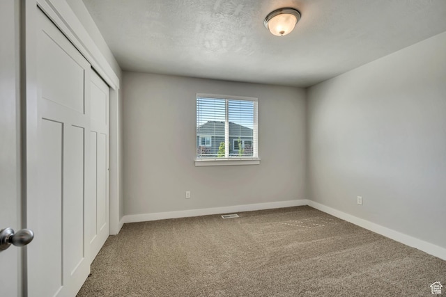 10966 S Coastal Dune Dr, South Jordan, UT 84009 - unfurnished bedroom featuring carpet, baseboards, a closet, and a textured ceiling