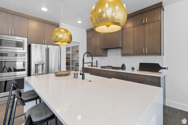 2041 W Pinnacle Ave, Mapleton, UT 84664 - kitchen featuring stainless steel appliances, light countertops, a kitchen breakfast bar, backsplash, and recessed lighting