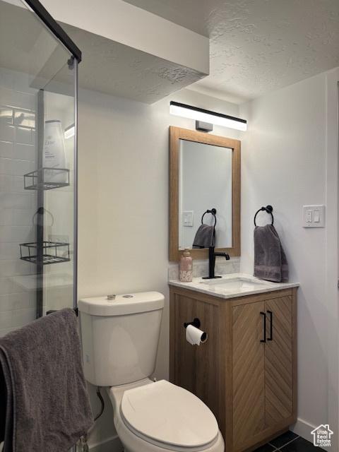 495 E 34 S Unit 10, Orem, UT 84097 - full bath with vanity, toilet, a stall shower, a textured ceiling, and baseboards