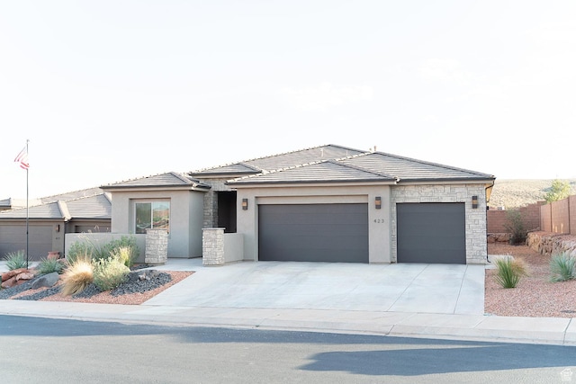 423 W Fitness Way, Ivins, UT 84738 - prairie-style house with stone siding, stucco siding, a garage, concrete driveway, and a tiled roof