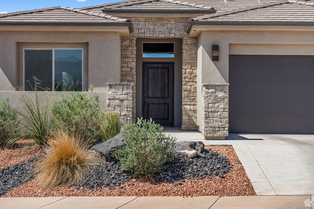 423 W Fitness Way, Ivins, UT 84738 - property entrance featuring stone siding, a tile roof, a garage, and stucco siding