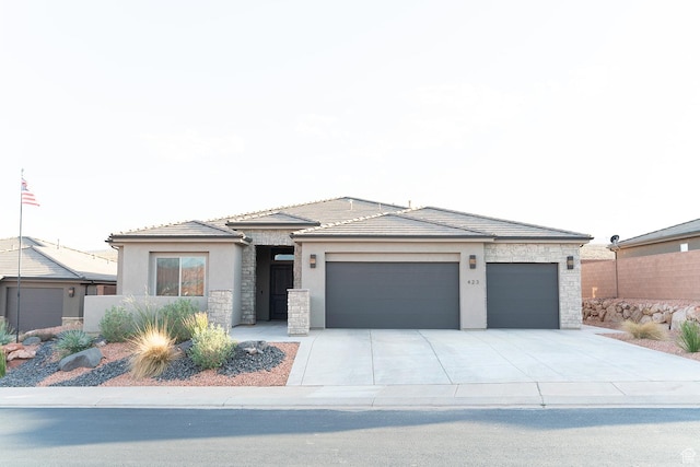423 W Fitness Way, Ivins, UT 84738 - prairie-style house featuring stone siding, stucco siding, a garage, driveway, and a tiled roof