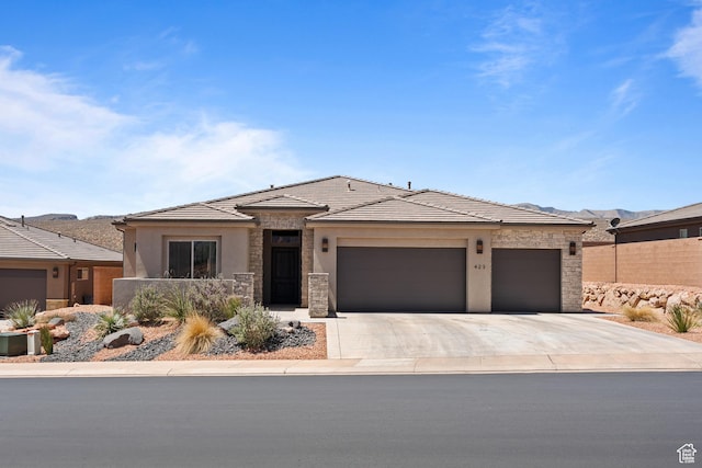 423 W Fitness Way, Ivins, UT 84738 - prairie-style house featuring a garage, stone siding, concrete driveway, stucco siding, and a tiled roof