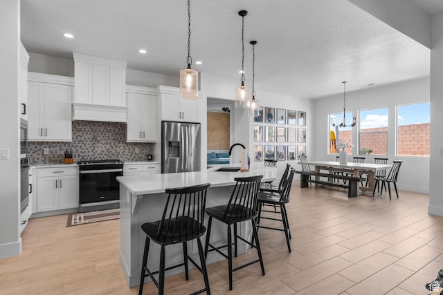 423 W Fitness Way, Ivins, UT 84738 - kitchen featuring appliances with stainless steel finishes, light countertops, tasteful backsplash, a sink, and an island with sink
