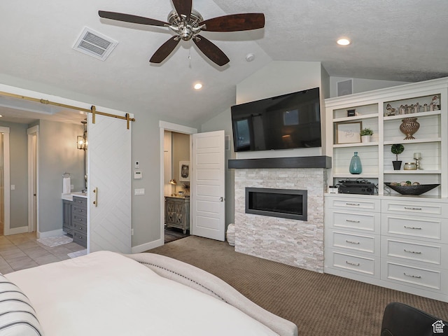 13772 S Kennington Ct E, Draper, UT 84020 - bedroom featuring a barn door, lofted ceiling, a stone fireplace, carpet, and baseboards