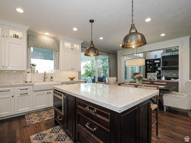 13772 S Kennington Ct E, Draper, UT 84020 - kitchen with a sink, white cabinetry, dark wood finished floors, backsplash, and recessed lighting