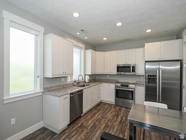 13772 S Kennington Ct E, Draper, UT 84020 - kitchen with appliances with stainless steel finishes, a sink, dark wood-style flooring, white cabinetry, and recessed lighting