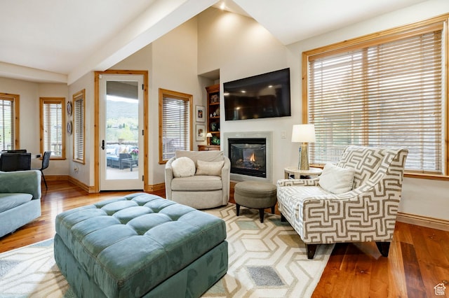 3006 E Canyon Links Dr S, Park City, UT 84098 - living room featuring baseboards, wood finished floors, a glass covered fireplace, plenty of natural light, and lofted ceiling
