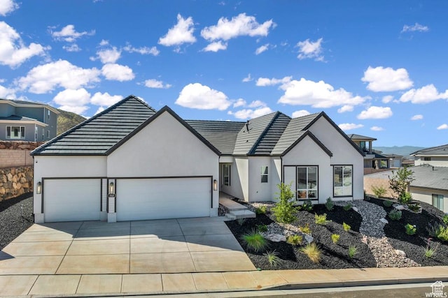1585 E Black Brush Dr Unit 61, Washington, UT 84780 - view of front of property featuring an attached garage, concrete driveway, stucco siding, and a tile roof