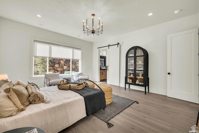 1585 E Black Brush Dr Unit 61, Washington, UT 84780 - bedroom with a barn door, light wood-style flooring, a chandelier, recessed lighting, and connected bathroom