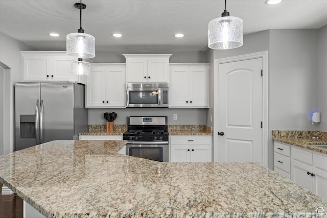 277 N 3600 W, Layton, UT 84041 - kitchen featuring appliances with stainless steel finishes, a kitchen island, white cabinets, recessed lighting, and light stone counters